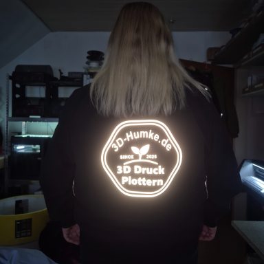 Reflektor Folie Schwarze Jacke mit leuchtendem Logo "30 Drunk Platten" auf dem Rücken.