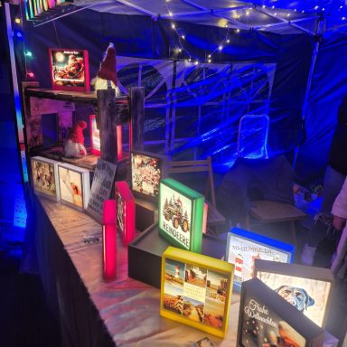 Ein Marktstand mit bunten Lichtern und leuchtenden Bücherständen.